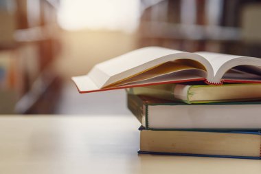 Kütüphanede, okulda, üniversitede, üniversitede kitap yığınları hakkında açık kitap.
