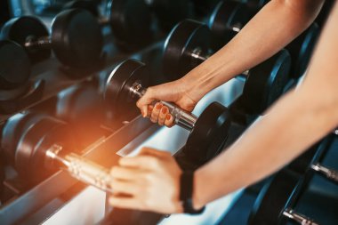 Kadınlar, spor salonunda dambıl kaldırarak egzersiz yaparlar. Spor salonunda spor yapan kadınlar..