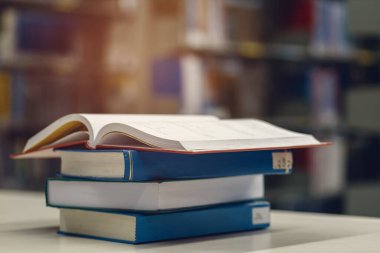 Kütüphanede, okulda, üniversitede, üniversitede kitap yığınları hakkında açık kitap.