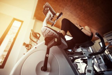 Spor salonunda egzersiz bisikleti kardiyo çalışması. Spor salonunda spor bisikleti süren kadınlar..