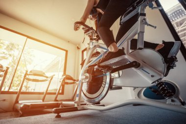 Spor salonunda egzersiz bisikleti kardiyo çalışması. Spor salonunda spor bisikleti süren kadınlar..
