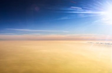 Sabahları gökyüzünü görmek için uçak penceresinden bak.