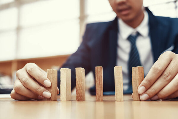 Мужская рука укладывает деревянные блоки. Концепция развития и роста бизнеса