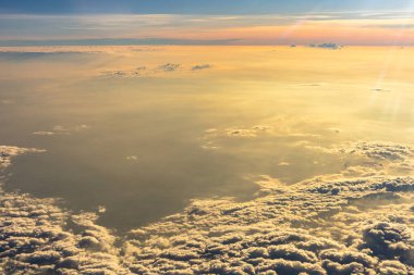 Bulutların üzerinde dramatik bir ışıkla güzel bir gün doğumu. Uçaktan kabin görüntüsü