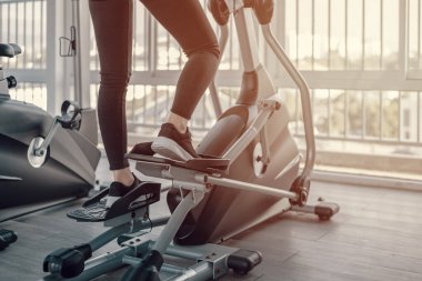 Spor salonunda eliptik antrenör kullanan genç kadınlar..