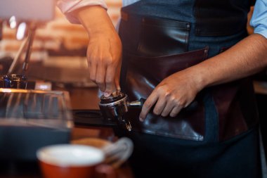 Barista portafilter tutuyor ve kafede kahve yapıyor.. 