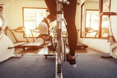 Spor salonunda egzersiz bisikleti kardiyo çalışması. Spor salonunda spor bisikleti süren kadınlar..