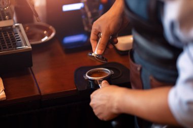 Barista portafilter tutuyor ve kafede kahve yapıyor.. 
