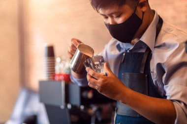 Kahveci kapuçino yapıyor. Kahve hazırlamak için süt dolduruyorum. Latte sanatı.