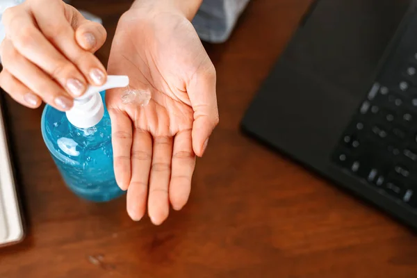 Working from home. Cleaning hands with sanitizer gel. Business