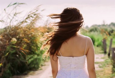 Kız güneş ışığı altında nature sırtında ile ayakta