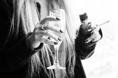 bir kız bir bardağı şampanya ve bir ciga tutan eller