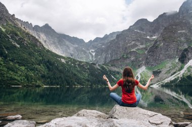 Genç fitness kadın dağ Gölü kıyısında meditasyon