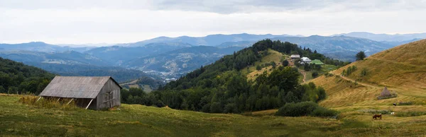 Красивый панорамный вид на низменный горный хребет, вагончики и сарай на берегу — стоковое фото