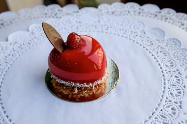 Ahududu ve çikolata yaprak üzerine kalp şeklinde kırmızı pasta