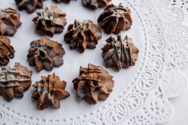 Pudra şekeri ve çikolata beyaz servette kürsüye pişmiş çerezleri kaplı