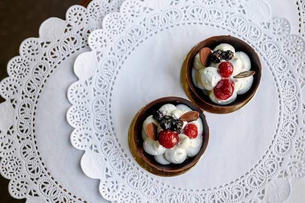 Посмотрите сверху на вкусные шоколадные миски с белыми сливками и ягодами внутри — стоковое фото