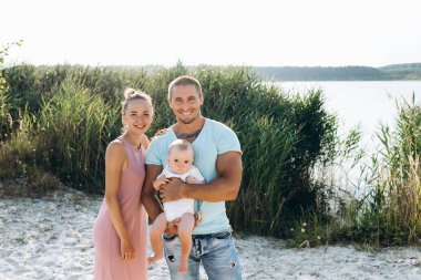 Mutlu baba ve anne ile küçük bir bebek evlat açık gülüyor.