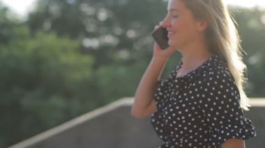 Çekici kız merdivenlerden iniyor ve akıllı telefondan konuşuyor.