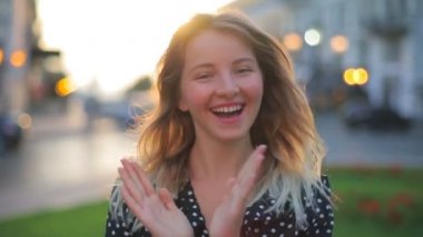 Güzel kız alkışlar ve neşeli bir gülümsemeyle dans eder.