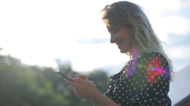 Puantiyeli çekici kız akıllı telefondan elbise giyiyor.