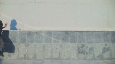 Yazlık elbiseli neşeli bayan poz verip kaçıyor.
