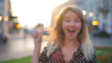 Çekici bir kadın işaret parmağı ve gülümsemesiyle ortaya çıkıyor.