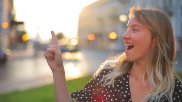 Mooie dame in polka dot top verhoogt index vinger en glimlacht — Stockvideo