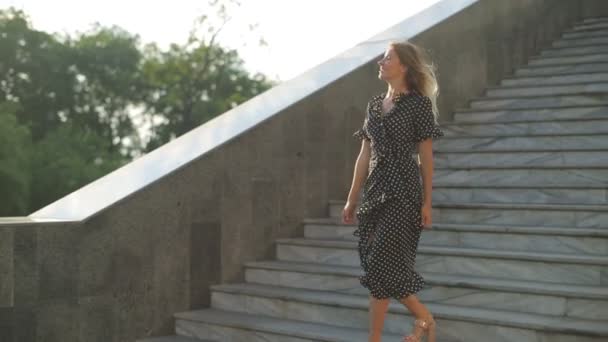 Mooi meisje stapt van grijze trap en toont duim-up — Stockvideo