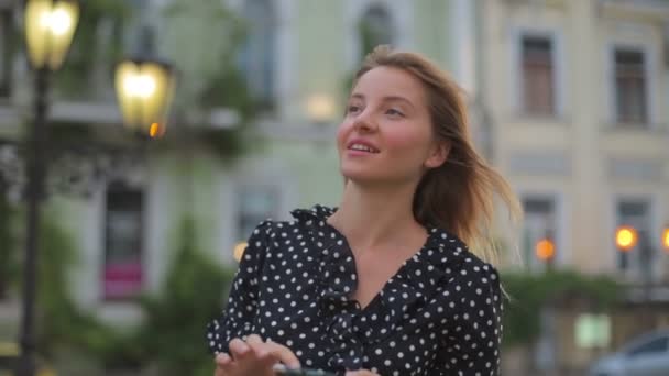 Blondes Mädchen läuft abends durch die Stadt und surft im Internet — Stockvideo