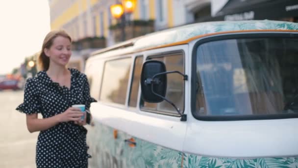 Junge Frau hält an getuntem Auto und trinkt Kaffee-Zeitlupe — Stockvideo