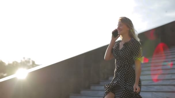 Aantrekkelijk model loopt grote trap af verlicht door de zomerzon — Stockvideo