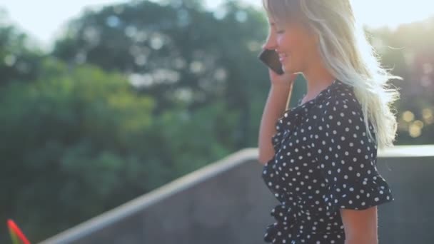 Modelo bonito com cabelo solto longo iluminado por passeios de sol e fala — Vídeo de Stock