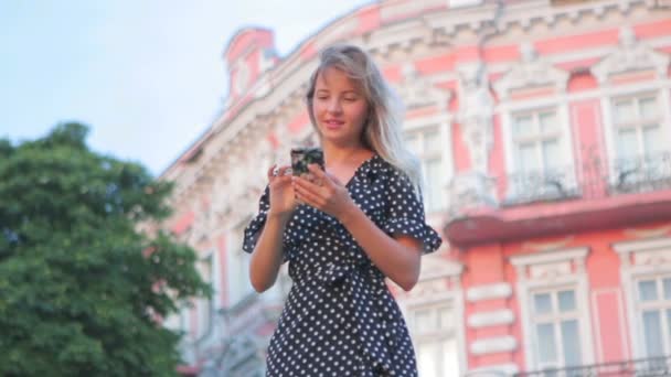 Hermosa chica mira a su alrededor y tipos en el teléfono inteligente moderno — Vídeos de Stock