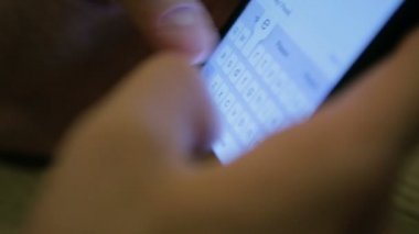 Adam arkadaşlarıyla sosyal ağlarda kafede telefon kullanarak sohbet ediyor.