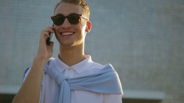 Gars parle avec des amis en utilisant gadget et pose près du bâtiment — Video