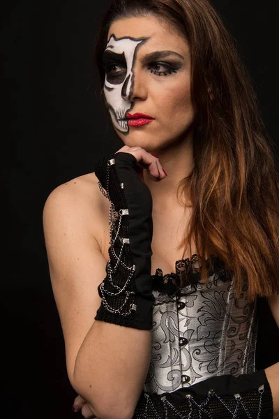 Model with a silver corset and a makeup for Halloween or carnivals
