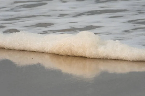 Seifenschaum am Strand, man muss weniger Waschmittel verwenden — Stockfoto