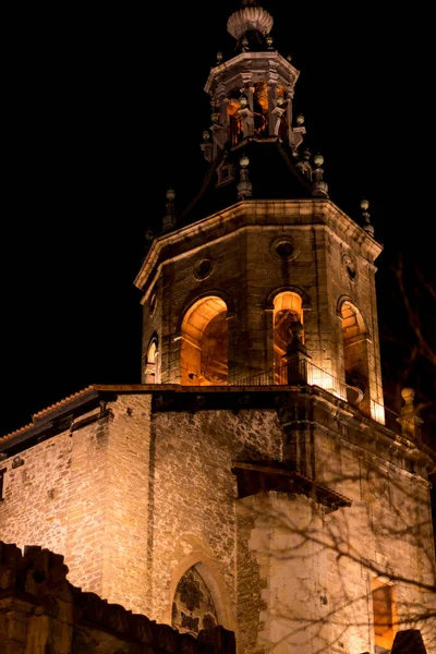 Foto del campanario de una catedral por la noche con luces naranjas — Foto de Stock