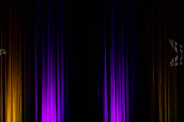 Black backdrop with purple lights in a theater