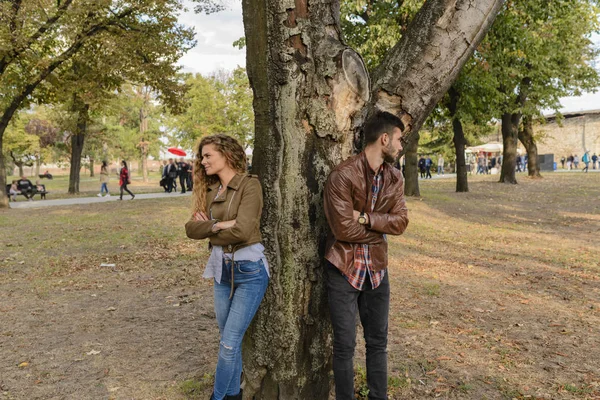 Casal jovem ignorando uns aos outros no parque público — Fotografia de Stock