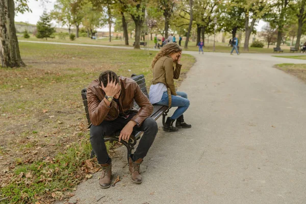 Pareja joven con problemas de amor sentada en el parque de la ciudad — Foto de Stock