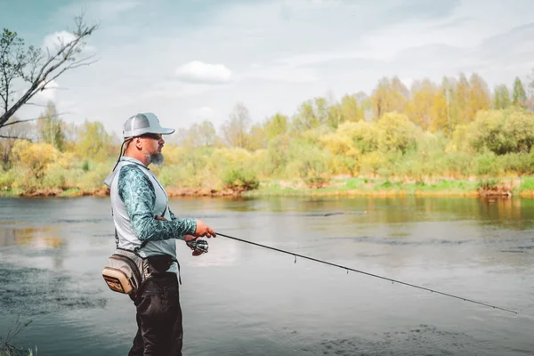 Visser met een staaf van de spinnen vangen van vis op een rivier — Stockfoto