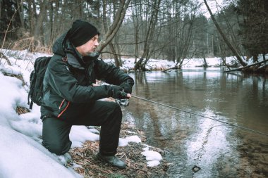 Nehir kıyısında oltası olan balıkçı..