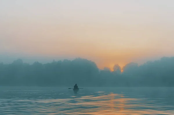 Pescador nada em um caiaque no rio . — Fotografia de Stock