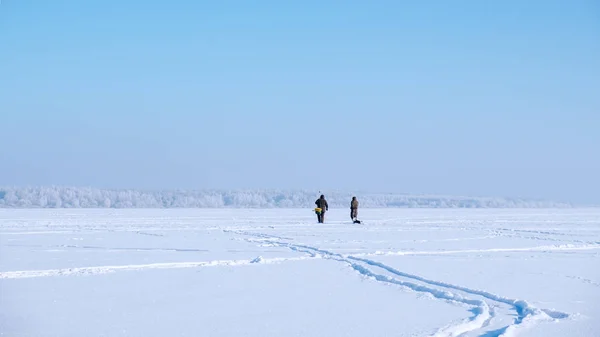 Ein einsamer Fischer auf einem zugefrorenen See. Eisfischen. — Stockfoto