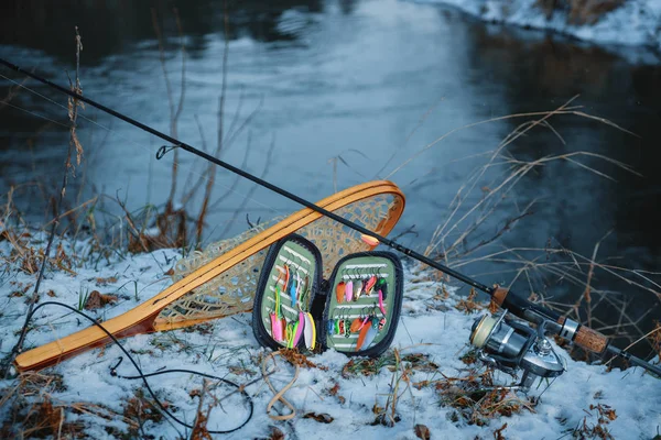Attrezzatura da pesca sulla riva di un fiume invernale . — Foto Stock