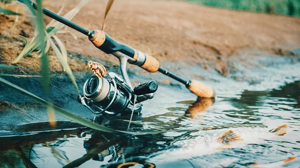 Filatura e mulinello sullo sfondo del lago. Attrezzi da pesca . — Foto Stock