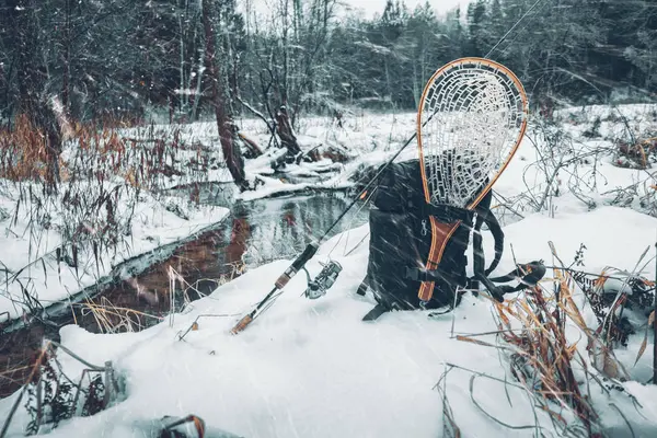 Equipamento de pesca na margem de um rio de inverno . — Fotografia de Stock