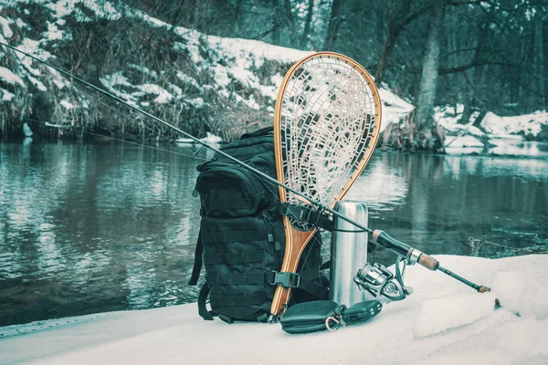 冬の小川の岸に釣り道具. — ストック写真